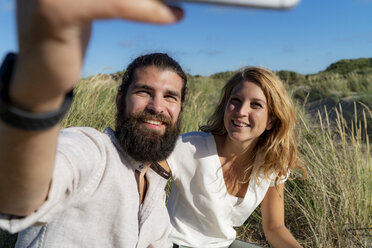Glückliches Paar nimmt Smartphone Selfie in der Natur - HHLMF00463