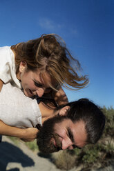 Young man carrying his girlfriend piggyback in the dunes - HHLMF00468