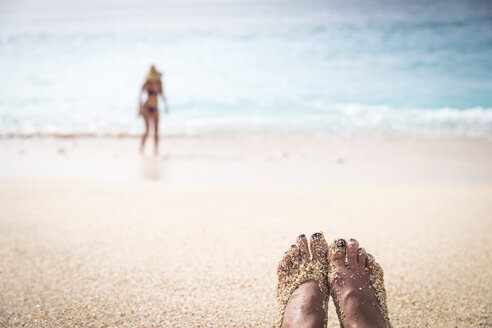 Mit Sand bedeckte Füße einer Frau am Strand - AURF04802