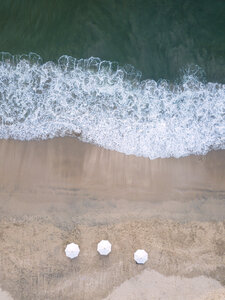 Indonesien, Bali, Luftaufnahme von Jimbaran Strand, weiße Sonnenschirme von oben - KNTF01467