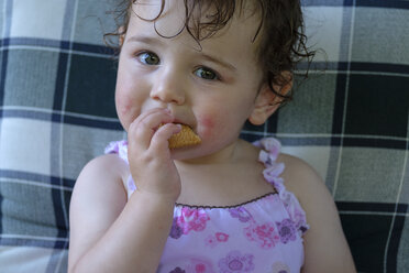 Portrait of content baby girl eating cookie - LBF02058