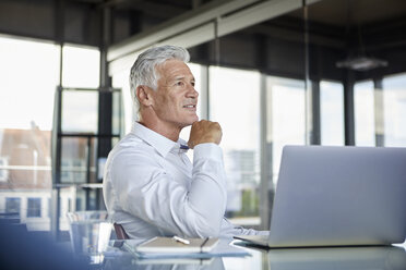 Businessman sitting in office, thinking - RBF06578