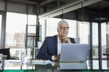 Businessman sitting in office, thinking - RBF06587