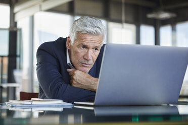 Geschäftsmann sitzt am Schreibtisch und versucht, ein Problem zu lösen - RBF06600