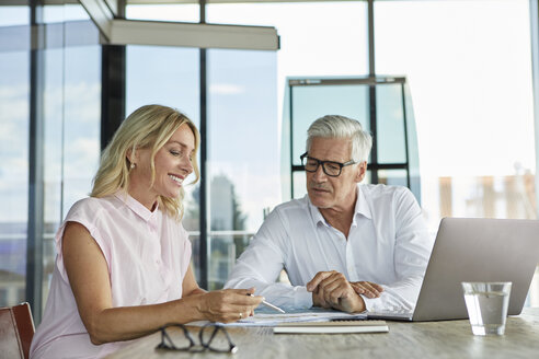 Geschäftsmann und Frau sitzen im Büro und besprechen ein Projekt - RBF06621