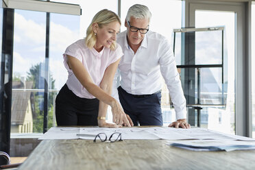 Businessman and woman discussing project in office - RBF06629