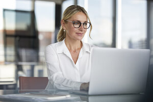 Geschäftsfrau bei der Arbeit im Büro, mit Laptop - RBF06638