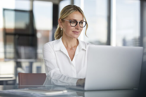 Geschäftsfrau bei der Arbeit im Büro, mit Laptop - RBF06638