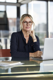 Geschäftsfrau bei der Arbeit im Büro, mit Laptop - RBF06642