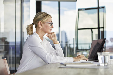 Geschäftsfrau bei der Arbeit im Büro, mit Laptop - RBF06702