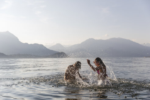 Glückliches junges Paar spielt in einem See - MRAF00275