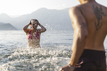 Glückliches junges Paar spielt in einem See - MRAF00278