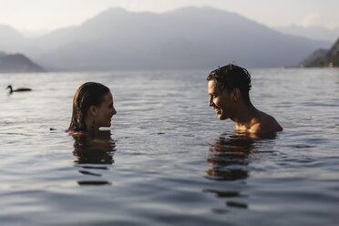 Happy young couple in a lake smiling at each other - MRAF00281