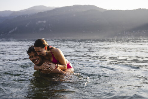 Happy playful young couple in a lake - MRAF00289