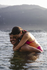 Happy playful young couple in a lake - MRAF00290