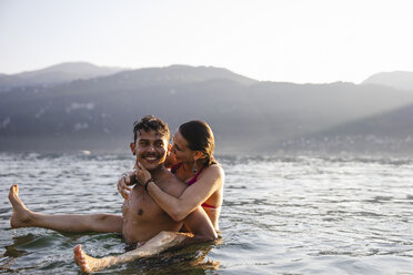 Happy playful young couple in a lake - MRAF00291