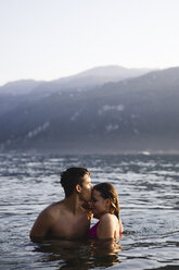 Affectionate young couple kissing in a lake - MRAF00294