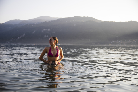 Lächelnde junge Frau in einem See, lizenzfreies Stockfoto