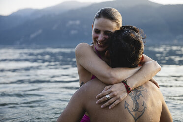 Glückliches junges Paar umarmt sich in einem See - MRAF00307