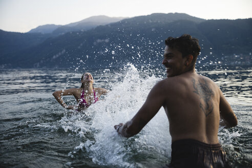 Glückliches junges Paar spielt in einem See - MRAF00308