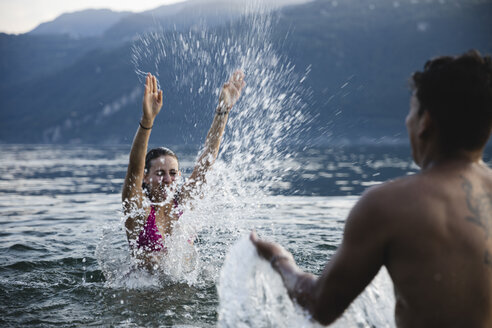 Glückliches junges Paar spielt in einem See - MRAF00309