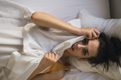 Porträt einer schönen jungen Frau im Bett liegend - KKAF01822