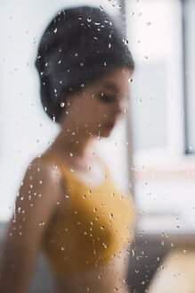 Blurred view of young woman with towel around her head at home - KKAF01828