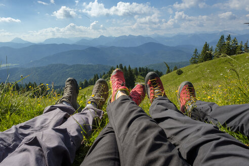 Deutschland, Bayern, Brauneck bei Lenggries, Beine von Wanderern auf einer Wiese in alpiner Landschaft - LBF02070