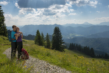 Deutschland, Bayern, Brauneck bei Lenggries, glückliches junges Paar bei einer Pause mit Blick auf die Alpenlandschaft - LBF02073