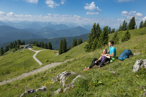 Deutschland, Bayern, Brauneck bei Lenggries, glückliches junges Paar bei einer Pause auf einer Wiese in alpiner Landschaft - LBF02074