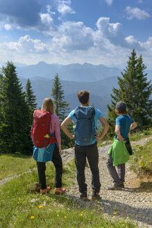 Deutschland, Bayern, Brauneck bei Lenggries, junge Freunde stehen in alpiner Landschaft und betrachten die Aussicht - LBF02083