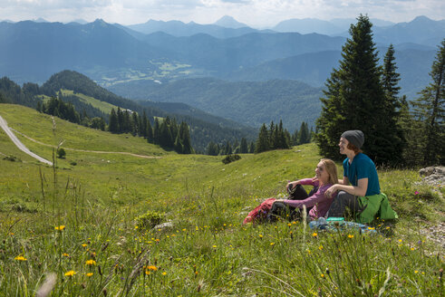 Deutschland, Bayern, Brauneck bei Lenggries, glückliches junges Paar bei einer Pause auf einer Wiese in alpiner Landschaft - LBF02085