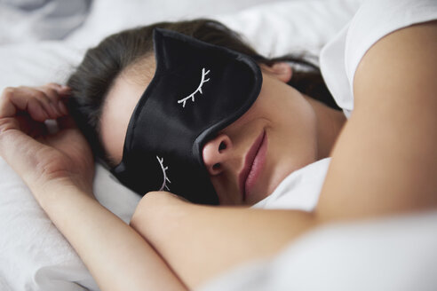 Portrait of young woman with sleep mask in bed - ABIF01007