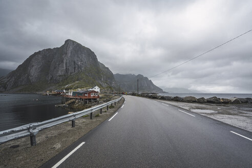 Norwegen, Lofoten, abgelegene Häuser an der Küste am Straßenrand - KKAF01860