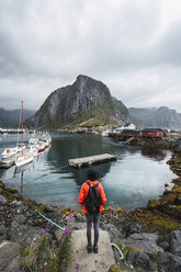 Norwegen, Lofoten, Rückansicht eines an der Küste stehenden Mannes - KKAF01861