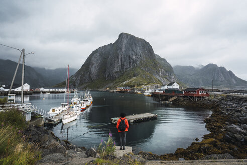 Norwegen, Lofoten, Rückansicht eines an der Küste stehenden Mannes - KKAF01862