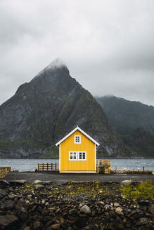 Norwegen, Lofoten, abgelegenes gelbes Haus an felsiger Küste - KKAF01868