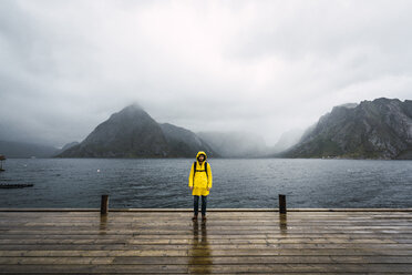 Norwegen, Lofoten, Mann steht auf einer Mole an der Küste - KKAF01870