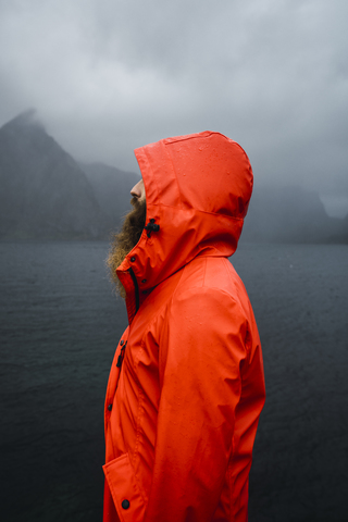 Norwegen, Lofoten, Profilansicht eines Mannes mit Vollbart an der Küste, lizenzfreies Stockfoto