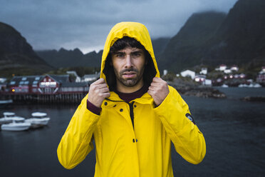 Norway, Lofoten, portrait of young man in a fishing village at the coast - KKAF01893