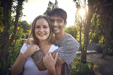 Glückliches junges Paar beim Flirten in einem Park im Sommer - SRYF00791