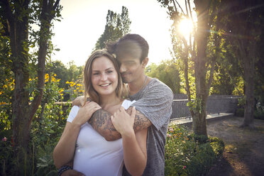 Glückliches junges Paar beim Flirten in einem Park im Sommer - SRYF00792