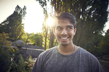 Portrait of a young man in a park at sunset, smiling - SRYF00795