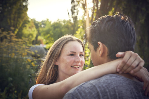 Glückliches junges Paar beim Flirten in einem Park im Sommer - SRYF00800