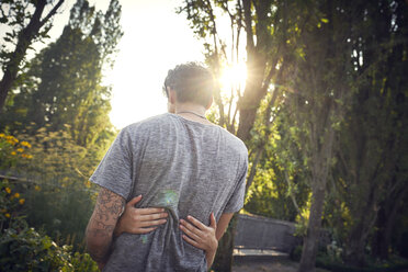 Happy young couple embracing and kissing in a park in summer - SRYF00804