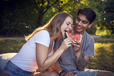 Junges Paar sitzt im Park und isst Wassermelone - SRYF00814