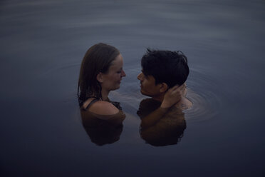 Romantic couple embracing in lake at sunset - SRYF00859