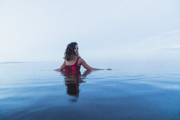 Woman wearing bikini, standing in water of a lake - KKAF01960