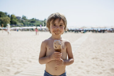 Porträt eines unordentlichen kleinen Jungen mit Eiswaffel am Strand - AZOF00026