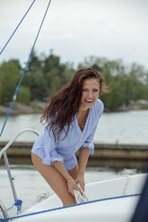 Frau auf Segelboot, die lachend ihr Seil festhält - JZF00013